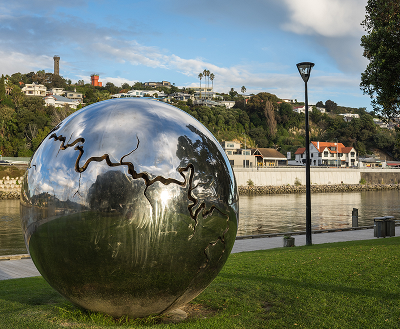 Large stainless steel ball art installation sculpture with a fissure denoting the Whanganui river cutting through it.