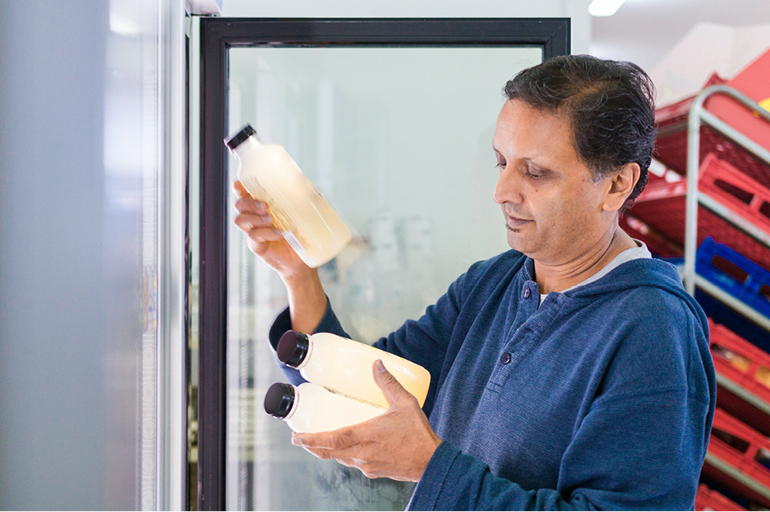 Workers stacks products into a store fridge