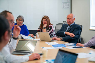 Group of people around a meeting table in a meeting.