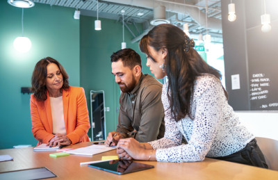 Three people in an office setting working together.