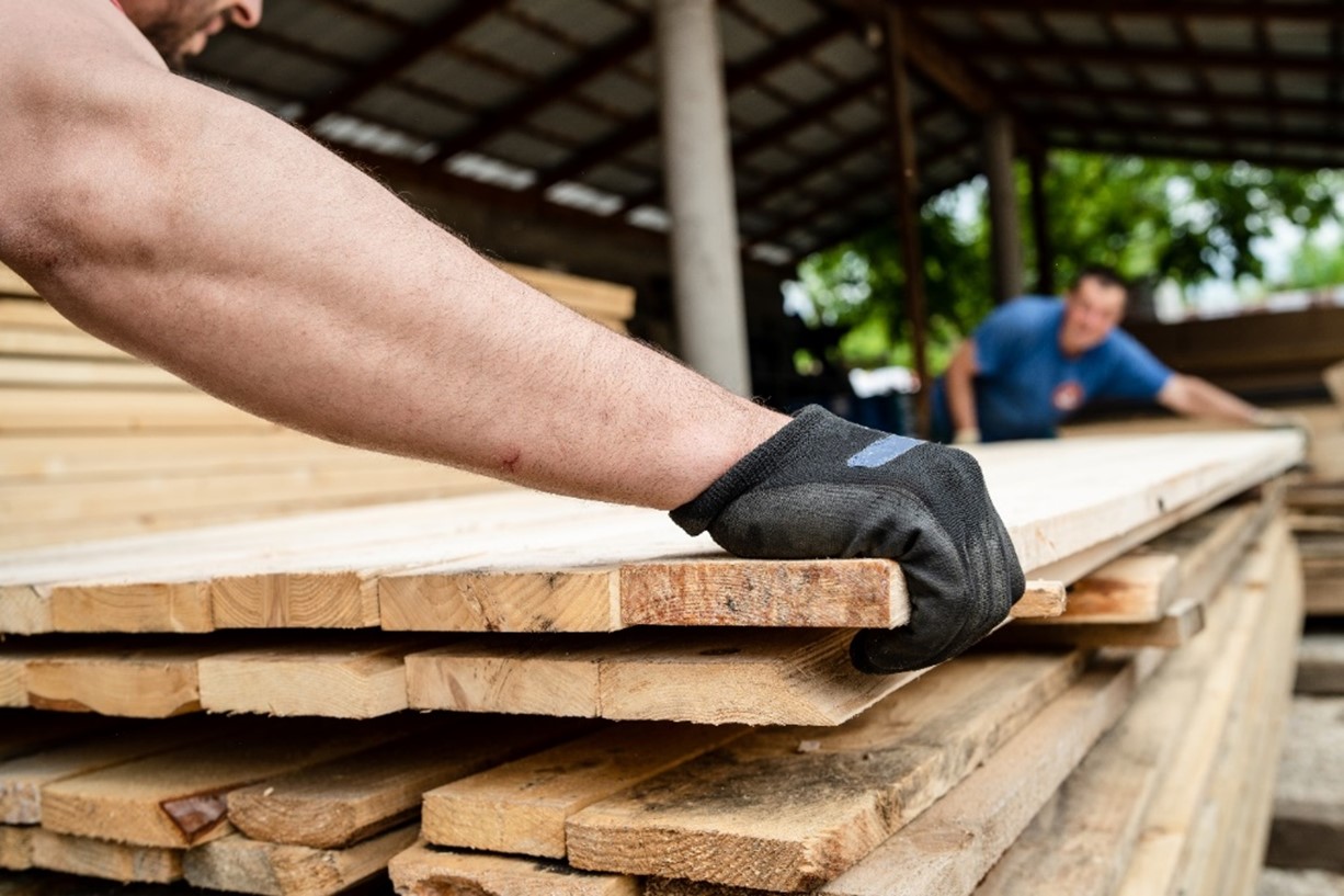 Two people lining up timber panels.