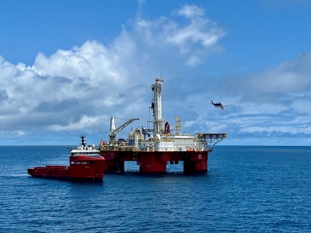 The Q7000 Heavy Well Intervention vessel with smaller vessel alongside and helicopter flying in background. 