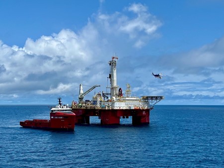 The Q7000 Heavy Well Intervention vessel with smaller vessel alongside and helicopter flying in background.