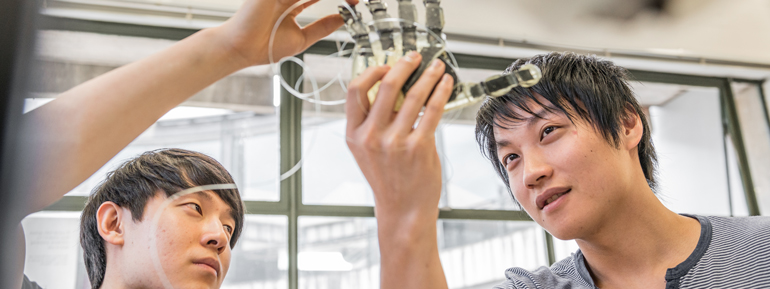 2 people looking at a bionic hand