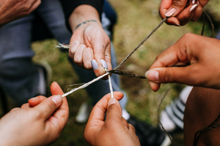 Hands holding small weaved rope