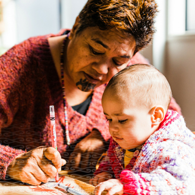 Woman drawing with baby watching