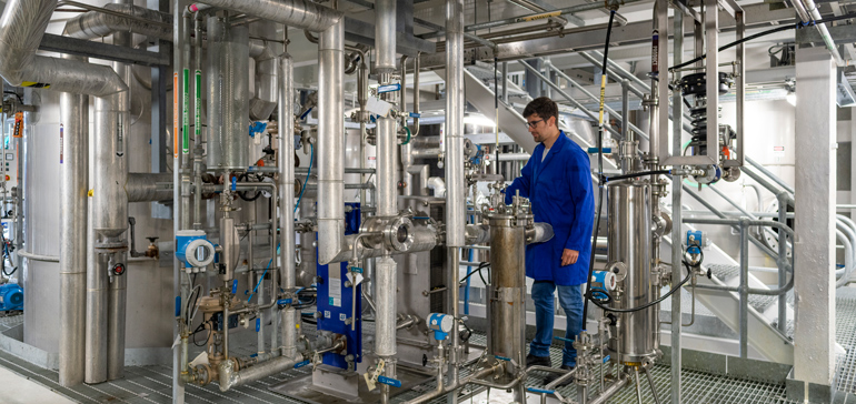 Person in blue jacket surrounded by machinery