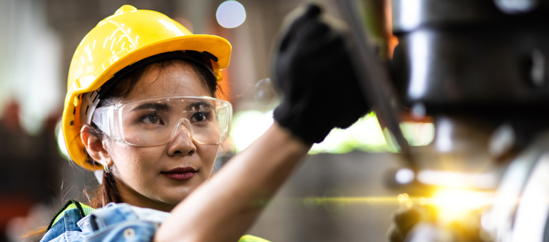 Women worker wearing safety glasses and yellow hard hat