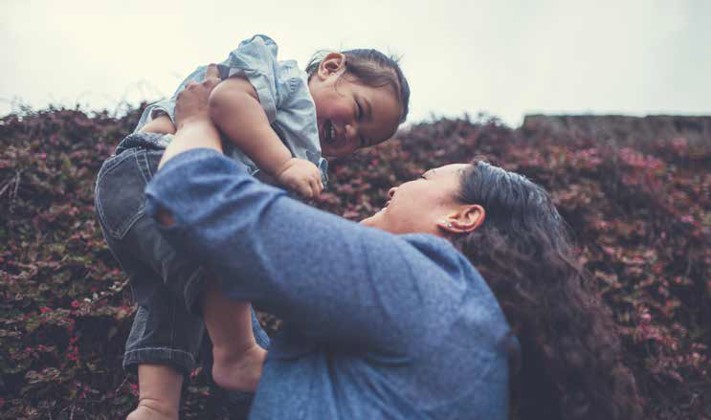 Mother lifting child up.
