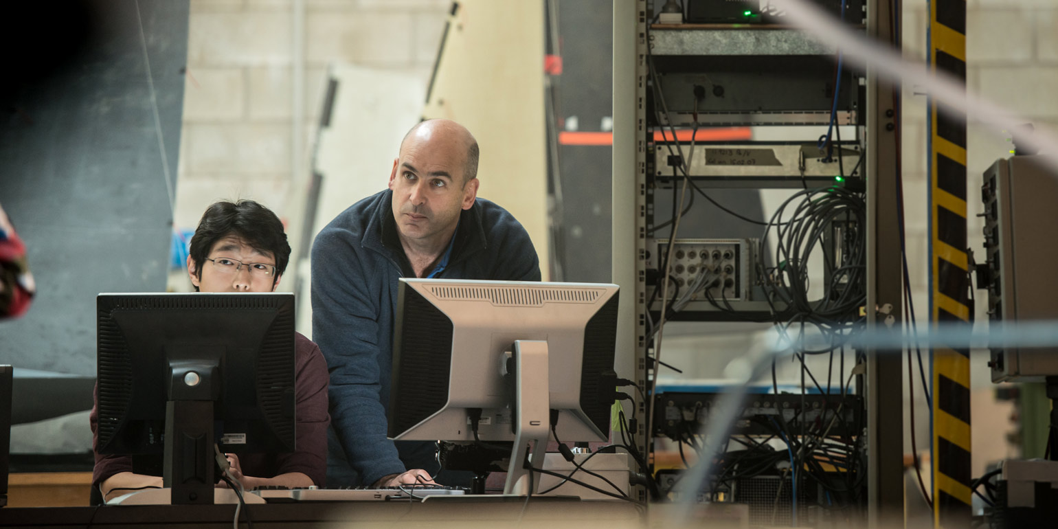 Two people behind computer screens