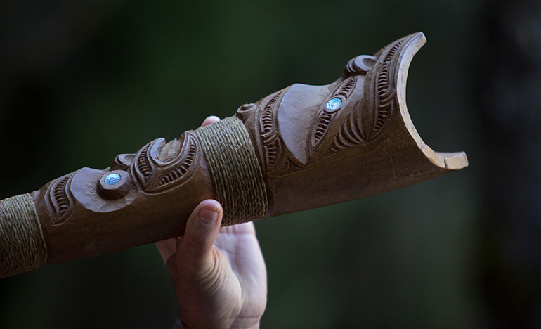 A hand holding a Māori carving