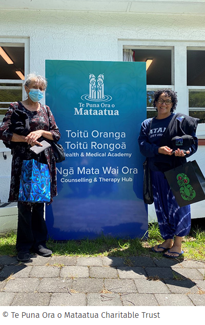 Two wahine stand on either side of Te Puna Ora o Mataatua signage © Te Puna Ora O Mataatua Charitable Trust