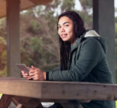 A young rangatahi woman using an electronic device