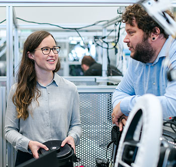 A young female engineer talks with a fellow worker