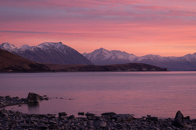 View across a lake to the Canterbury ranges at sunset