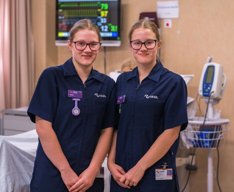 Two young women in nursing scrubs.