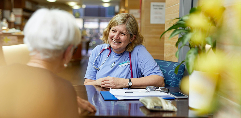 Care worker smiling at an elderly client.