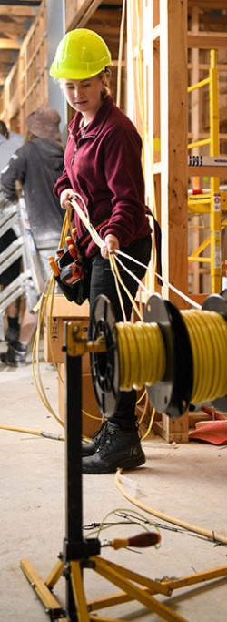 Construction worker uncoiling electrical cables