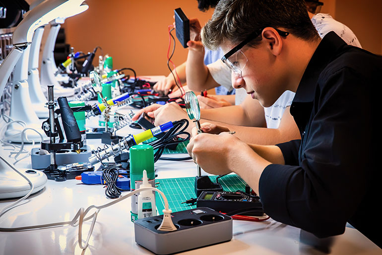 a young man soldering electronic components.