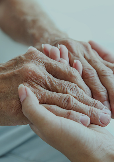 The clasped hands of an elderly woman and a young woman 