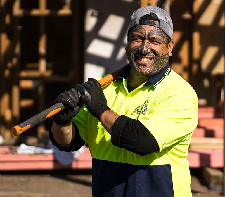 Man on building site holding sledge hammer (Te Pae Hākari)