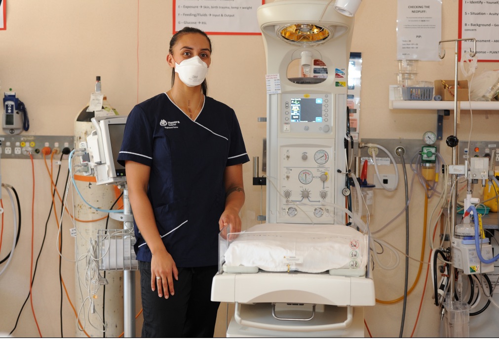 1 female nurse wearing a mask next to medical equipment