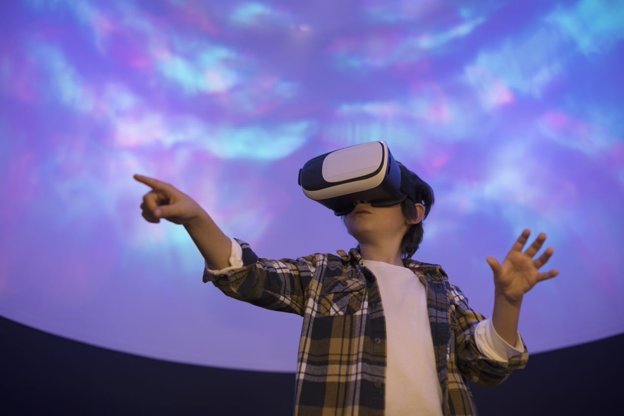 Kid wearing virtual reality goggles pointing