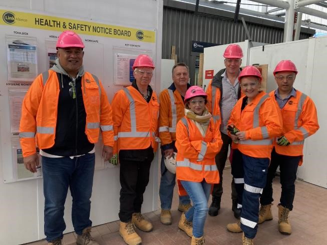 People posing for a photo and wearing hi vis and hard hats