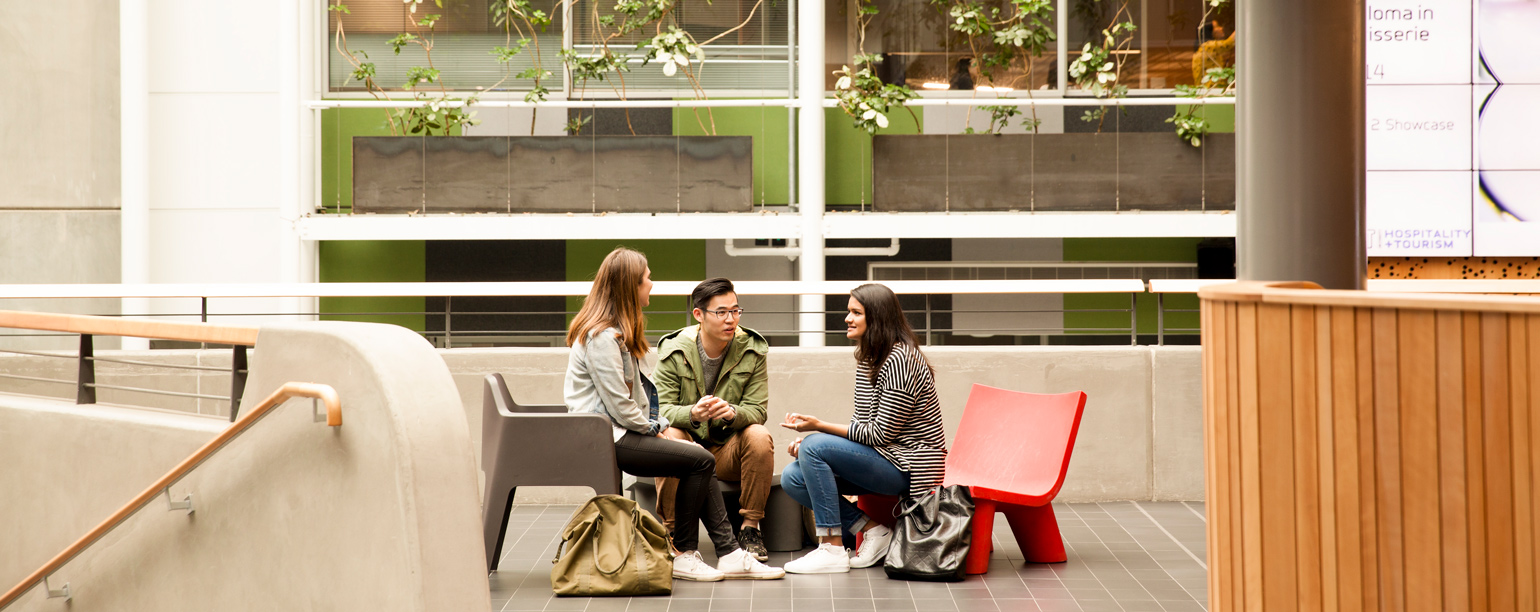 Young people on seats talking in an auditorium