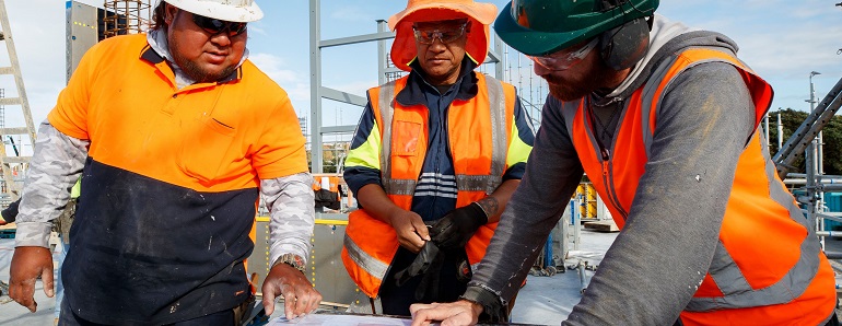 Three Pacific Construction Workers looking at a plan.