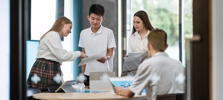 Four High School Students discussing a project.