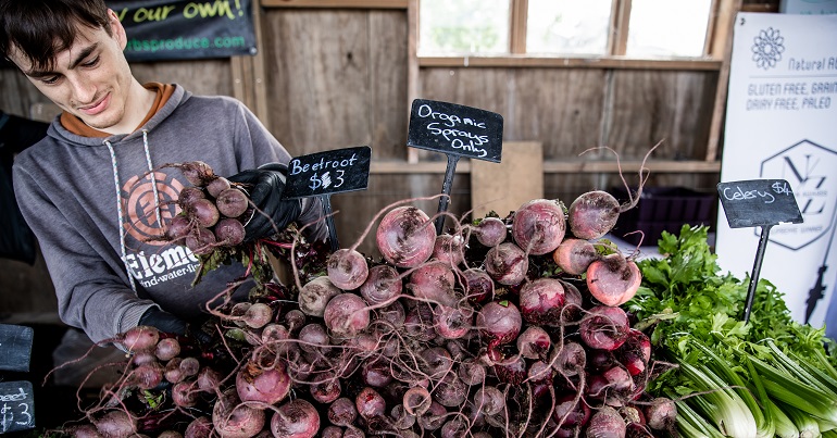 A man selling beetroot at market.