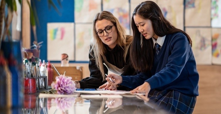 Female teacher and female high school student going over homework.