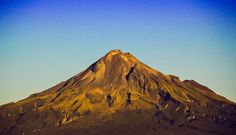 Mount Taranaki in summer with a blue sky.