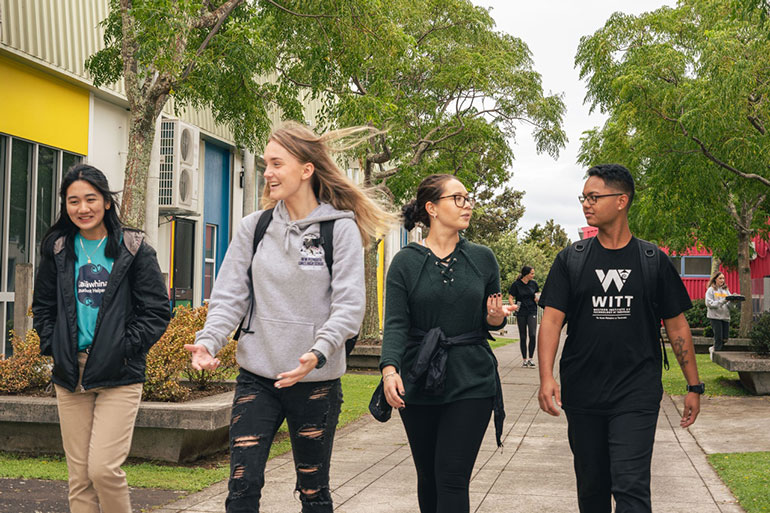 Four students walking through campus.