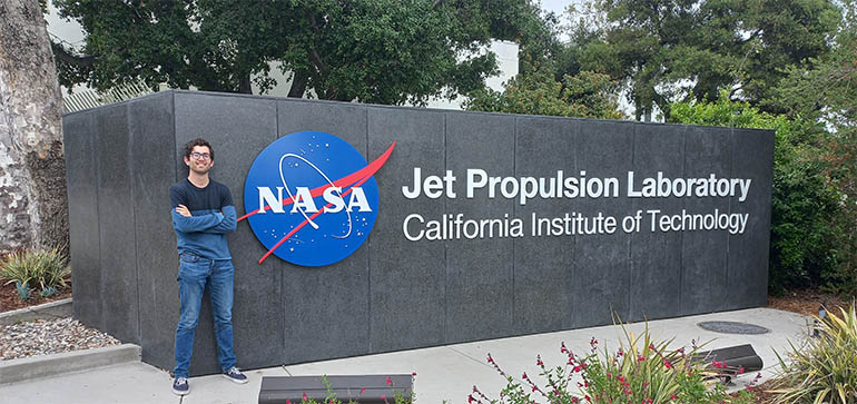 Intern Daniel Wrench standing in front of NASA JPL sign
