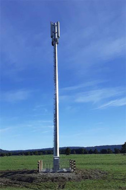 A mobile tower in the middle of a grassy paddock.