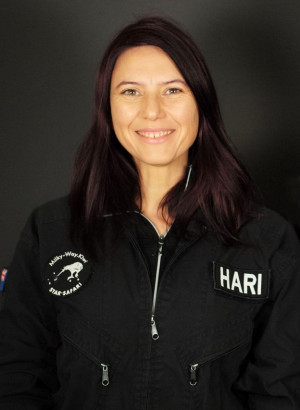 Headshot of Hari wearing a black New Zealand zip up with an emblem of a Kiwi