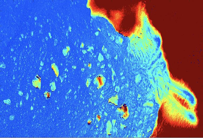 Image shows the glacier in Greenland with colours ranging from red to blue.