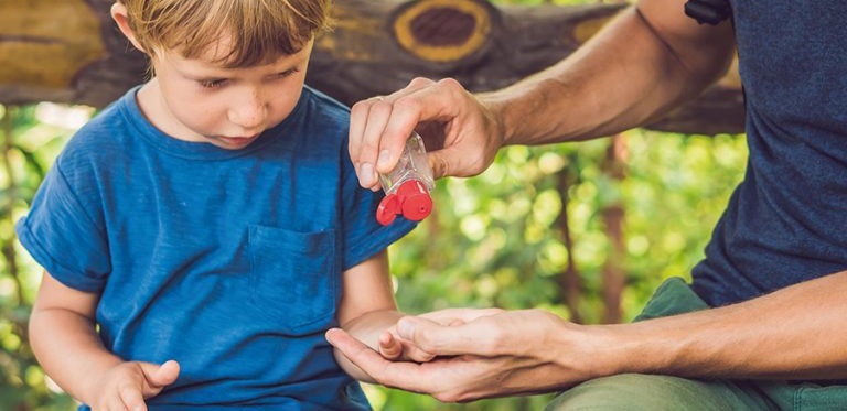 This image shows an adult figure assisting a young child to sanitise their hands. 