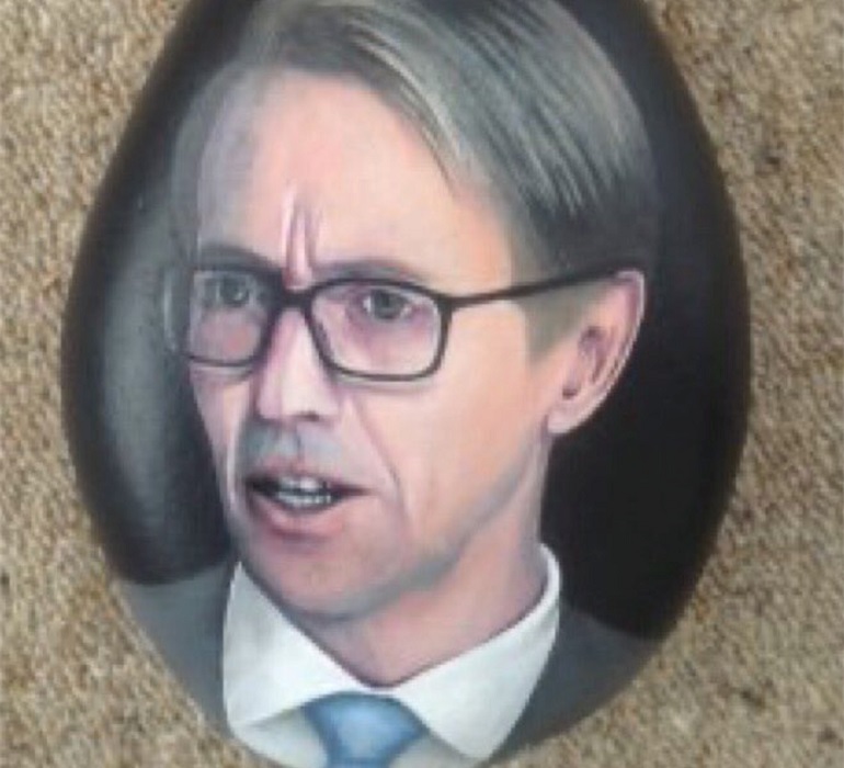 Portrait of the Director-General of Health, Ashley Bloomfield painted on a rock.