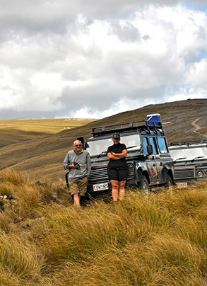 david and Amanda standing in front of a four wheel drive truck on a back country hillside.