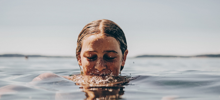 Girl swimming in the sea with her head out of the water 