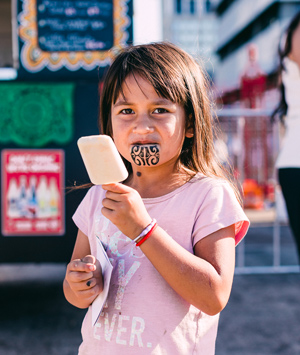 Girl with moko kauae holding an ice block