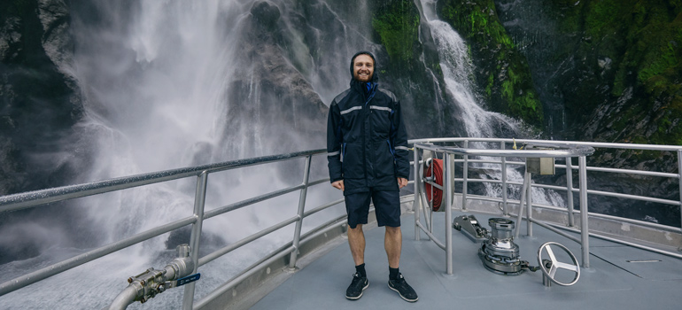 Milford sound waterfall with person in the foreground