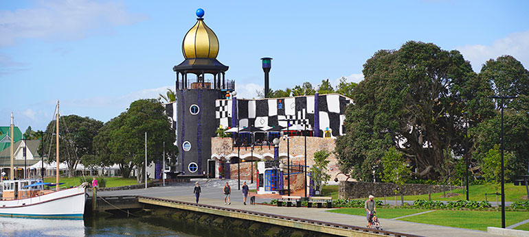 People walking along the waterfront in front of the Hundertwasser Art Centre in Whangarei