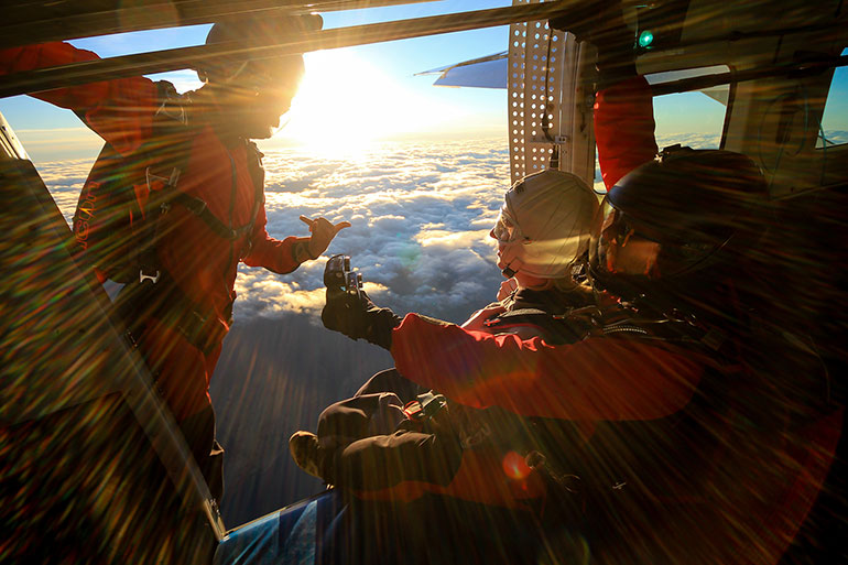 3 people getting ready to sky dive.