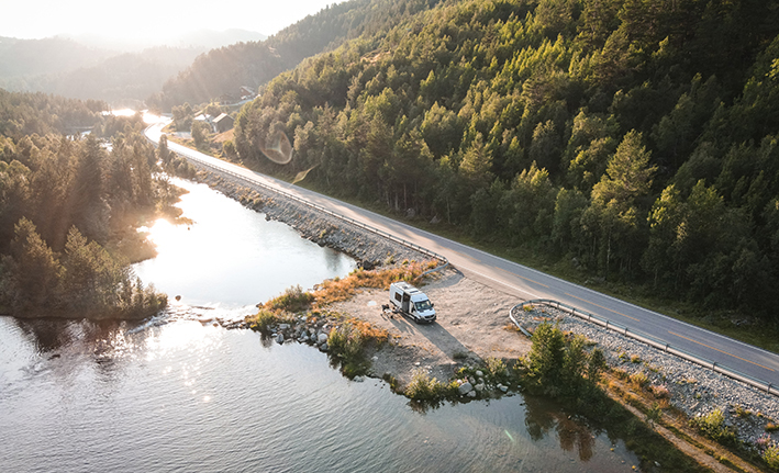 Photograph of a road beside a river with a campervan parked in a siding next to the river