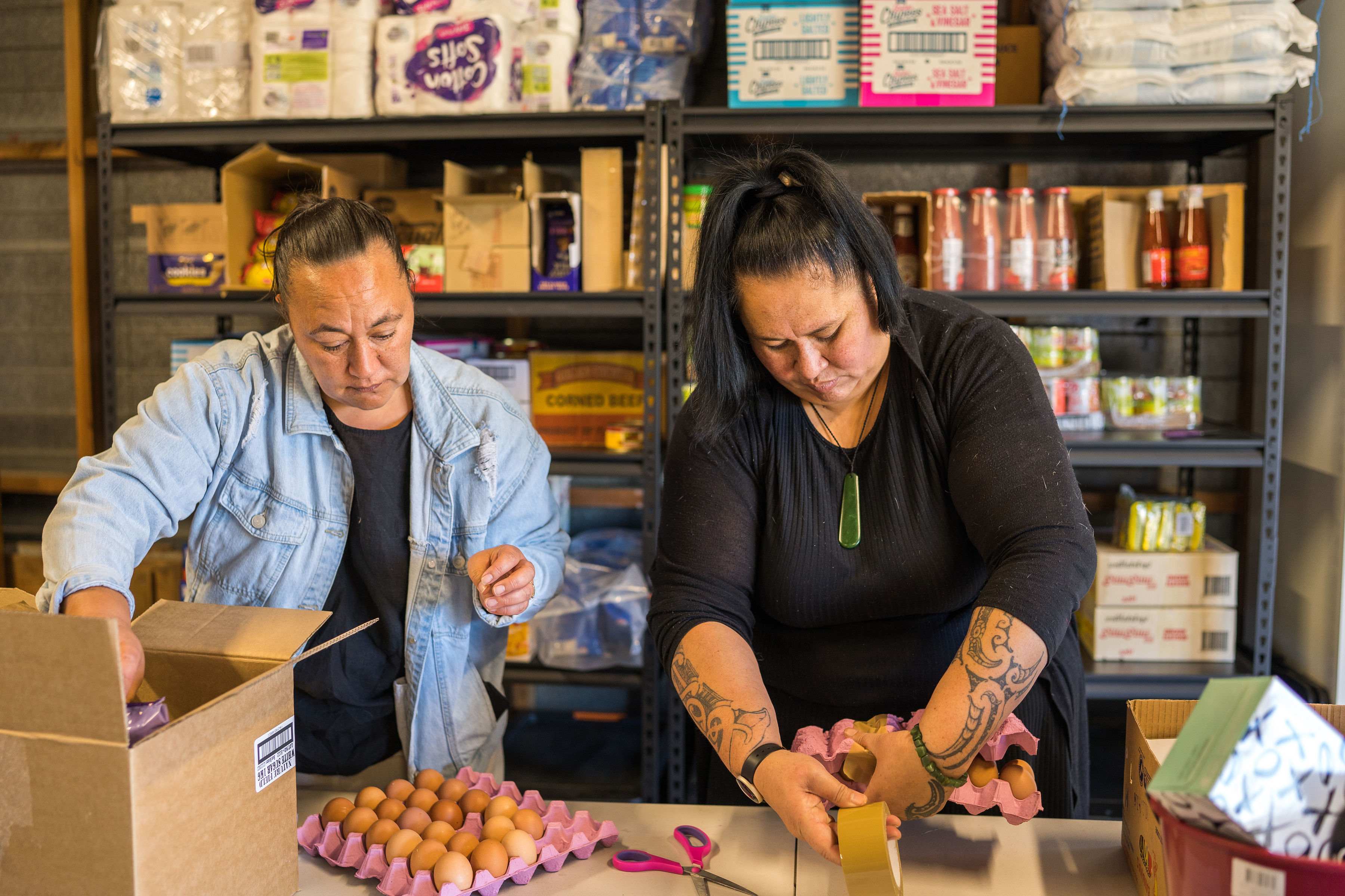 2 woman packaging egg cartons.