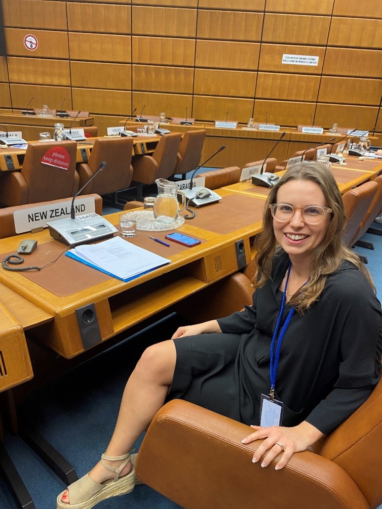 Rebecca Kingi sitting at a desk at the UN Transnational Organised Crime Convention Conference of the Parties Working Groups on Trafficking in Persons and Smuggling of Migrants in Vienna, Austria. 